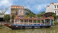 Double decker tour boat anchored along shore Thu Bon River, Hoi An
