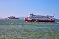 Double decker tour boat on choppy San Francisco Bay waters with Alcatraz Island in distance