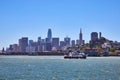 Double decker tour boat on choppy waters in San Francisco Bay with downtown skyscrapers