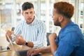 Double the effort brings double the rewards. two young businessmen having a meeting in a modern office.