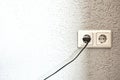 Double electrical power European socket with black cable and plug on white wall space for text Royalty Free Stock Photo