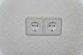 Double electrical socket (European standard) on a light wall. Royalty Free Stock Photo