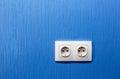 Double electrical socket and outlet on blue painted wall in the room in apartment is after construction, remodeling Royalty Free Stock Photo