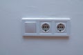 Double electrical wall socket with light switch on white wall Royalty Free Stock Photo