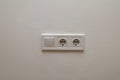 Double electrical wall socket with light switch on white wall Royalty Free Stock Photo