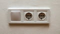 Double electrical wall socket with light switch on white wall Royalty Free Stock Photo