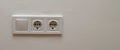 Double electrical wall socket with light switch on white wall Royalty Free Stock Photo