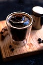 Double espresso coffee mug with cinnamon sticks and coffee beans on a wooden board