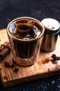 Double espresso coffee mug with cinnamon sticks and coffee beans on a wooden board