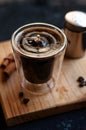 Double espresso coffee mug with cinnamon sticks and coffee beans on a wooden board