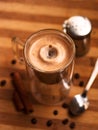 Double espresso coffee mug with cinnamon sticks and coffee beans on a wooden table