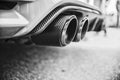 Double exhaust pipes of a modern sports car, black and white