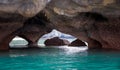 Double-exit cave with turquoise water below limestone rocks