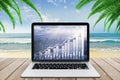 Double explosure with business chart and city view on laptop screen on wooden bench at the beach with ocean