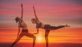 Double exposure background of two caucasian yoga partners having yoga workout posing with background of sunset sky