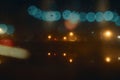 A double exposure of bokeh lights. With street lights and buildings reflected in a river on a spooky foggy night