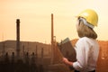Double exposure of business woman with oil refinery background