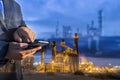 Double exposure of businessman checking oil refinery industry plant