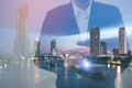 Double exposure businessman hand holding and touch screen smart phone with modern city background. Royalty Free Stock Photo