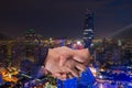 Double Exposure of a businessman handshake on bangkok cityscape