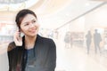 Double exposure of businesswoman talking phone with shopping mall