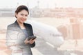 Double exposure of businesswoman using calculator with aeroplane