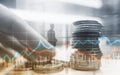 Double exposure of city and rows of coins with stock and financial graph on virtual screen. Business Investment concept. Royalty Free Stock Photo