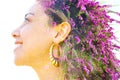 Double exposure close up profile portrait of a young pretty woman interwoven with bright purple Bougainvillea flowers seemingly Royalty Free Stock Photo