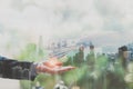 Double exposure concept. Close up of hands businessman exchange money and view of modern city background.