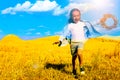 Double exposure of cute girl with flower wreath running in field and Ukrainian flag