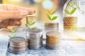 Double exposure hand holding coin, tree growing on money,alarm clock,saving account,investment concept