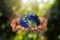 Double exposure of hands holding planet earth on blurred green nature background, elements of this image furnished Royalty Free Stock Photo