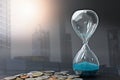 Double exposure of hourglass with coins for time of business