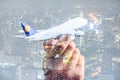 The double exposure image of the airplane model on hand overlay with cityscape image. the concept of travel, business, aircraft, i