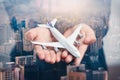 The double exposure image of the airplane model on hand overlay with cityscape image. the concept of travel, business, aircraft, i