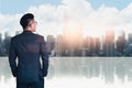 The double exposure image of the business man standing back during sunrise overlay with cityscape image. The concept of modern lif Royalty Free Stock Photo