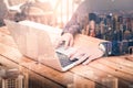 The double exposure image of the business man using a laptop computer during sunrise overlay with cityscape image. The concept of Royalty Free Stock Photo