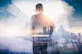 The double exposure image of the businessman standing back during sunrise overlay with cityscape image. The concept of modern life Royalty Free Stock Photo