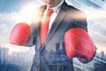 The double exposure image of the businessman wearing a boxing mitts overlay with cityscape image. the concept of fighting, trade w