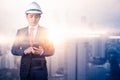 The double exposure image of the engineer using a smartphone during sunrise overlay with cityscape image. The concept of engineeri Royalty Free Stock Photo