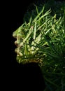 A double exposure portrait of a young woman's profile against black background and green foliage Royalty Free Stock Photo