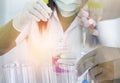 Scientist carrying research chemistry liquid to test tube with scientist hand dropping chemical liquid in science laboratory