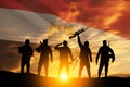 Double exposure of silhouettes of a soliders and the sunset or the sunrise against flag of Egypt.