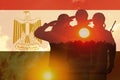 Double exposure of Silhouettes of soliders and the sunset or the sunrise against flag of Egypt.