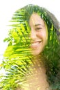 A double exposure of a smiling young woman`s portrait and palm tree leaves