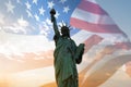 Double exposure with statue of liberty and United States flag blowing in the wind