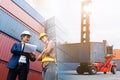 Asian foreman holding clipboard and engineering control loading containers cargo ship Royalty Free Stock Photo