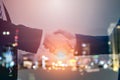 Double exposure two confident businessman shaking hands with city. Successful business partners. Negotiating business. Royalty Free Stock Photo