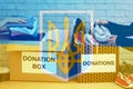 Double exposure of volunteers packing donation boxes and Ukrainian flag. Help during war