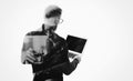 Double exposure young bearded consultant wearing black shirt and holding contemporary notebook hands.Blank screen ready for you me